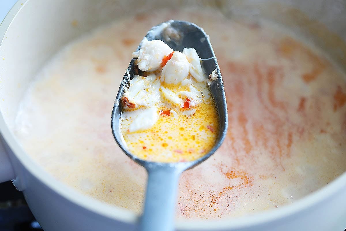 Lump crab meat and bisque on a ladle.