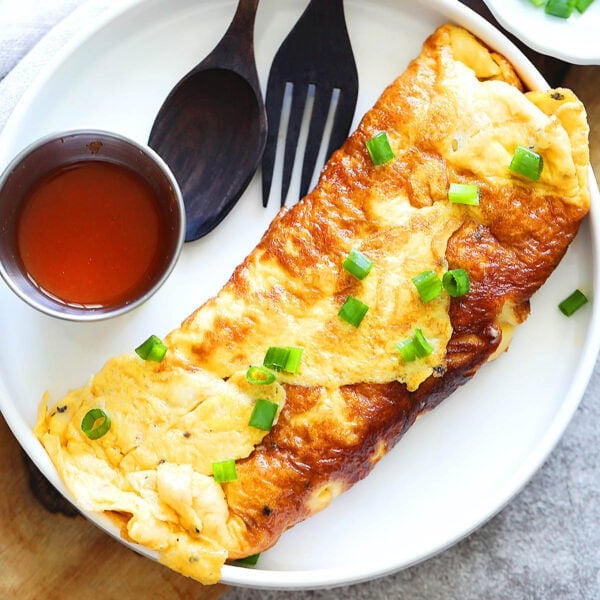 Crab omelette just like Jay Fai, garnished with scallions.