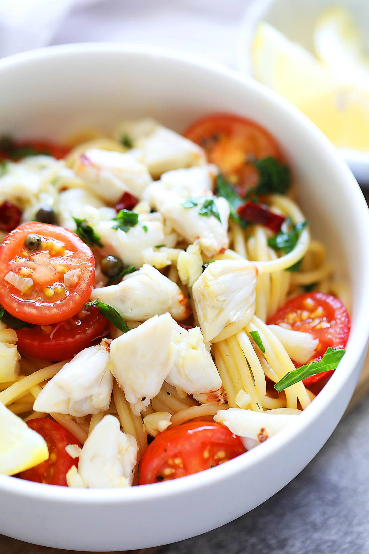 Crab pasta with white wine, garnished with parsley, served in a bowl.