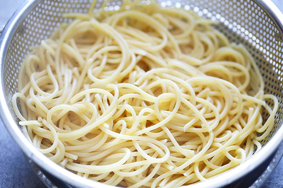 Cooked spaghetti in a strainer.