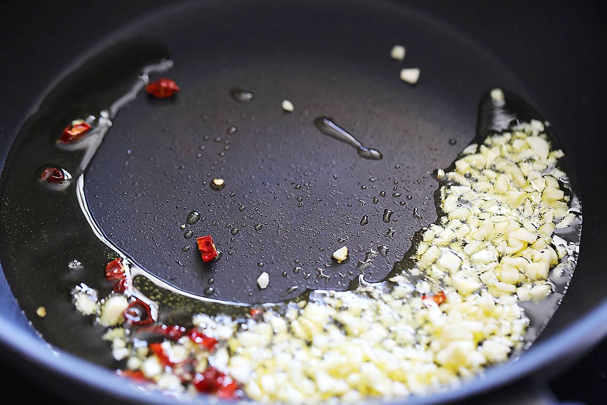 Olive oil, minced garlic and dried red chili in a pan.
