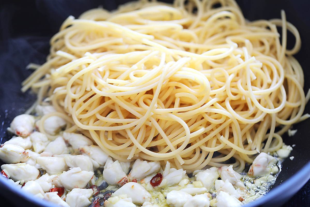 Crab lump meat and spaghetti in a pan.