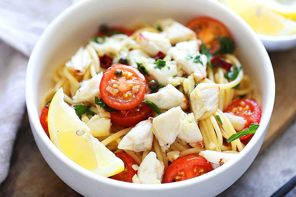 Easy and light crab pasta recipe with cherry tomatoes, capers, and parsley.