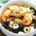 Squid ink pasta with seafood coated in a creamy and saucy tom yum sauce.