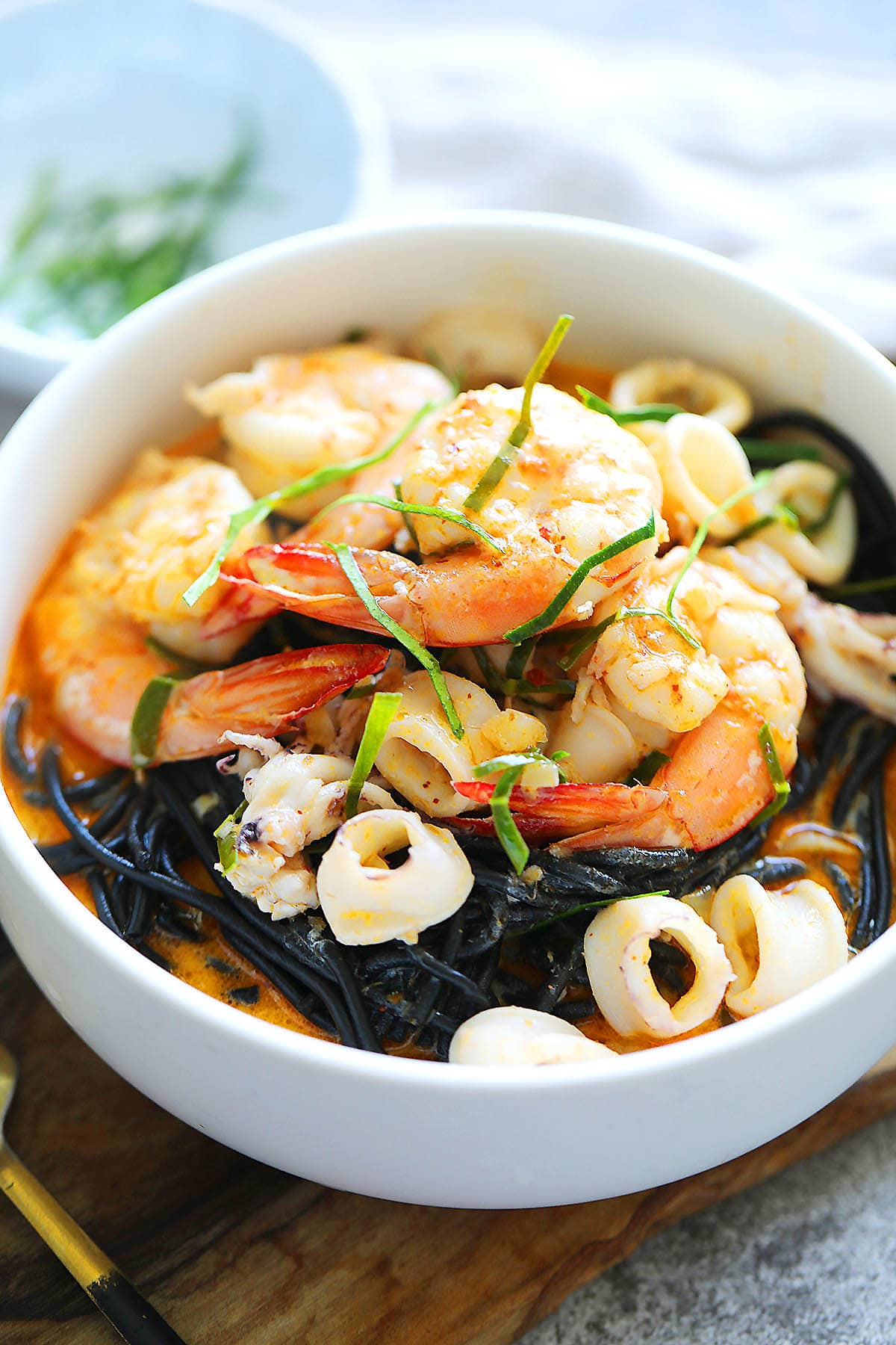 Squid ink pasta with seafood coated in a creamy and saucy tom yum sauce.