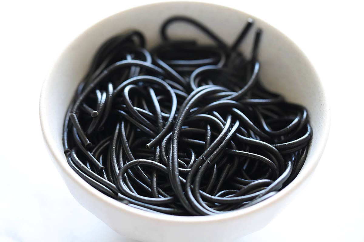 Cooked squid ink pasta in bowl.
