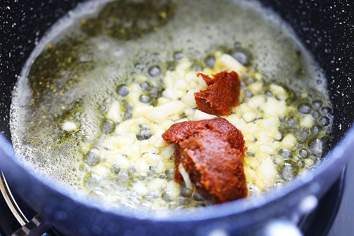 Melted butter, garlic, and tom yum paste in a saucepan.