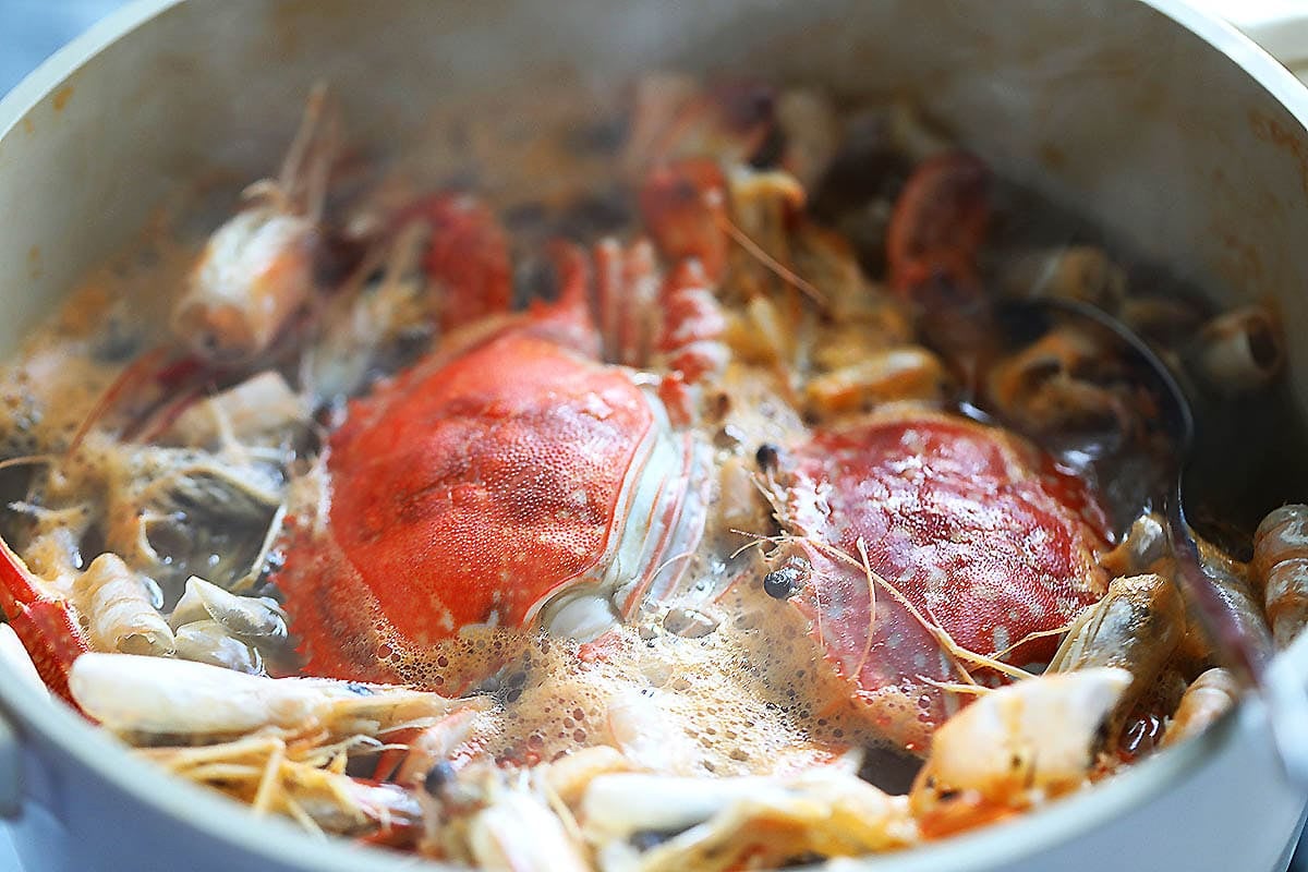 Crabs and shrimp shells in a pot of boiling water.
