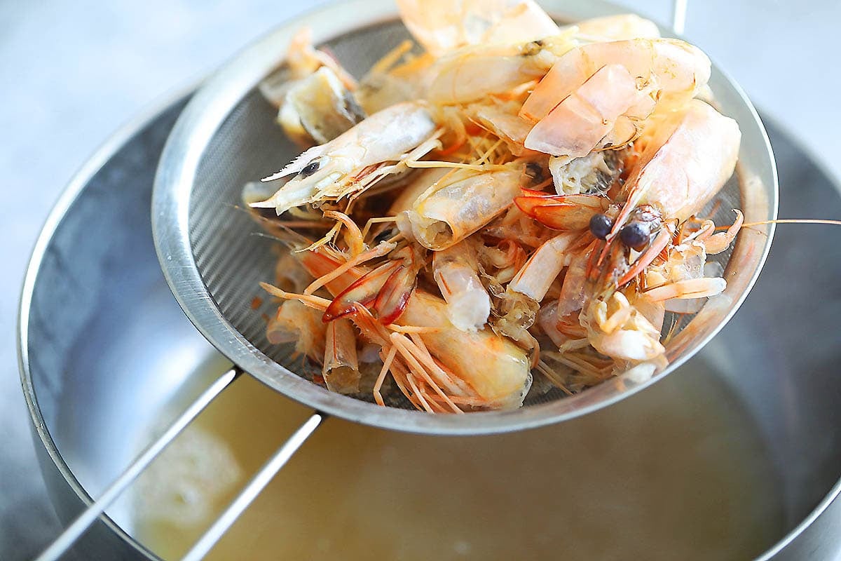 Shrimp shells on a fine mesh strainer.