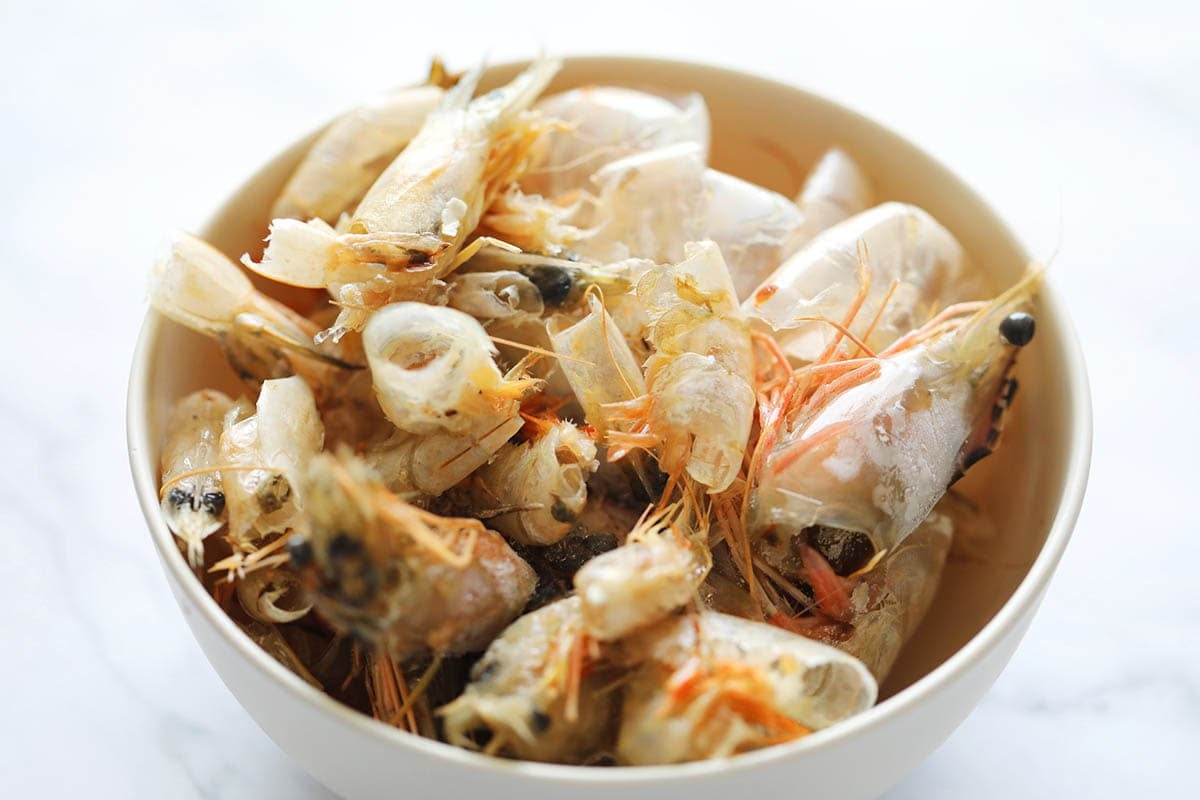 Shrimp shells and heads in a bowl.