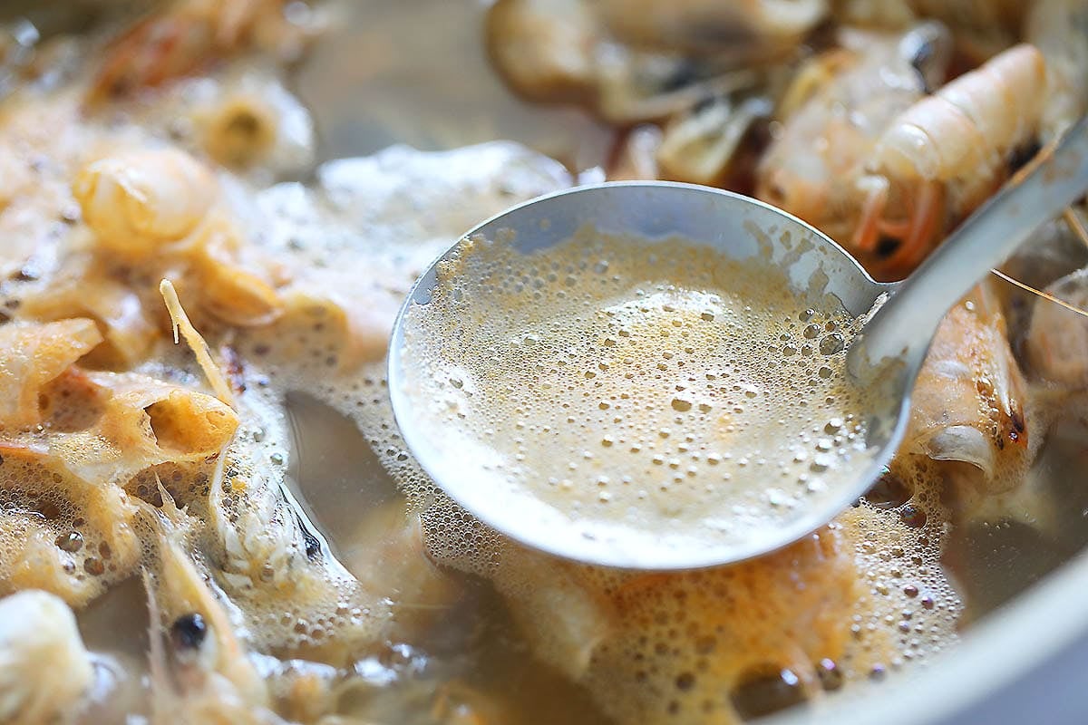A ladle of foam of the shrimp stock.