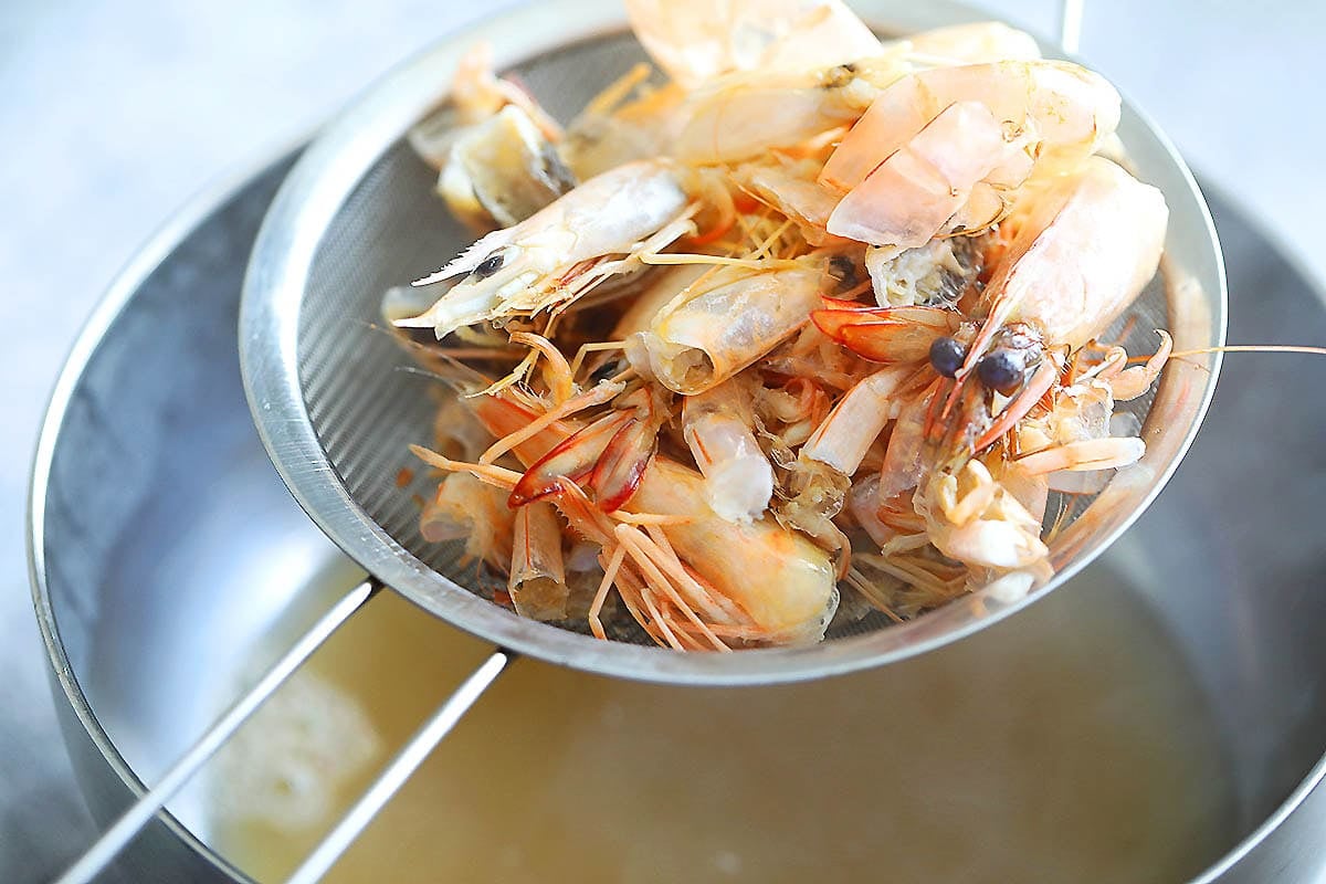 Shrimp shells and heads on a fine mash strainer.