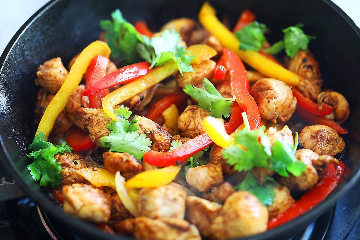 Easy chicken fajita sizzling in a cast iron skillet.