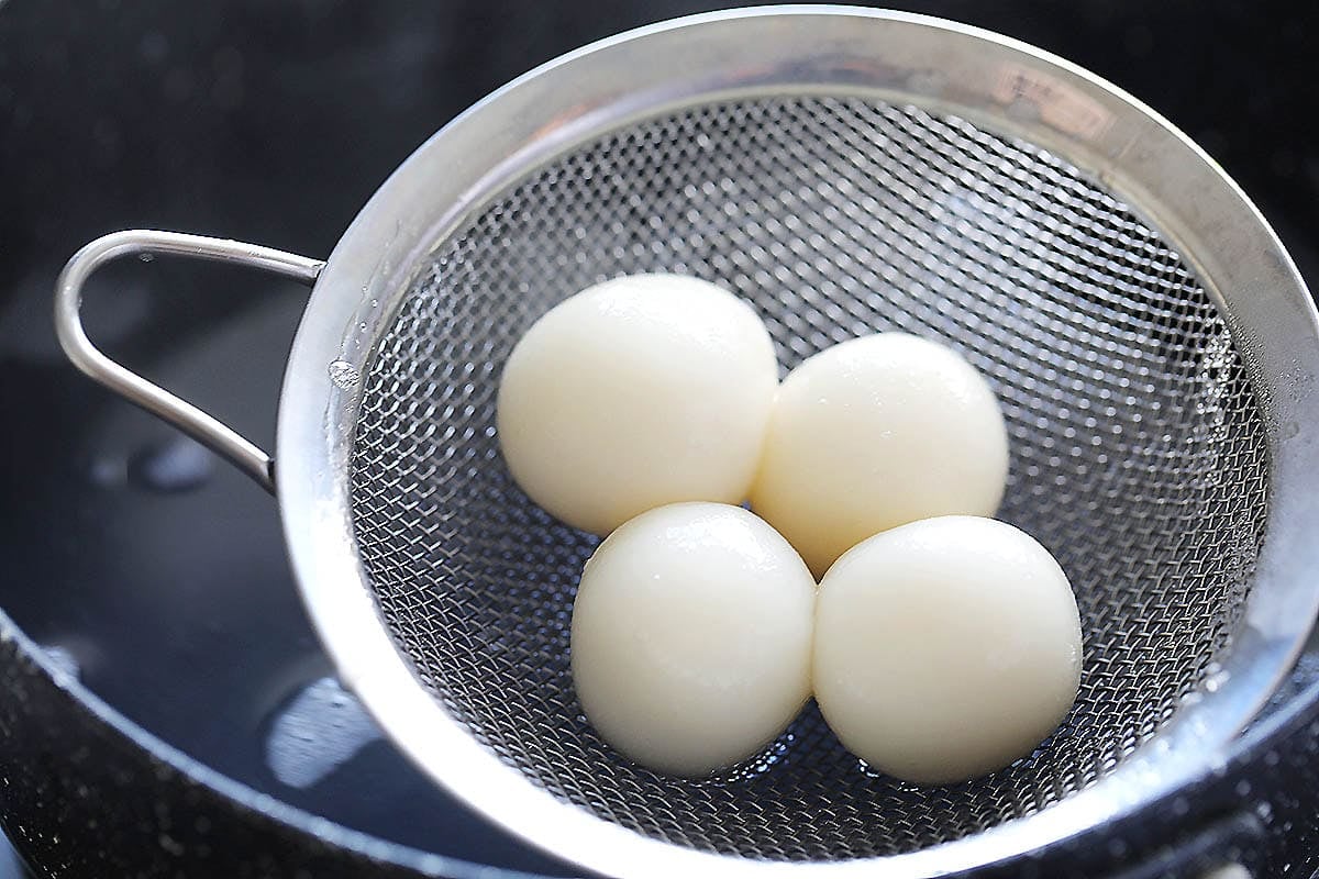 Cooked rice dumplings on a strainer.