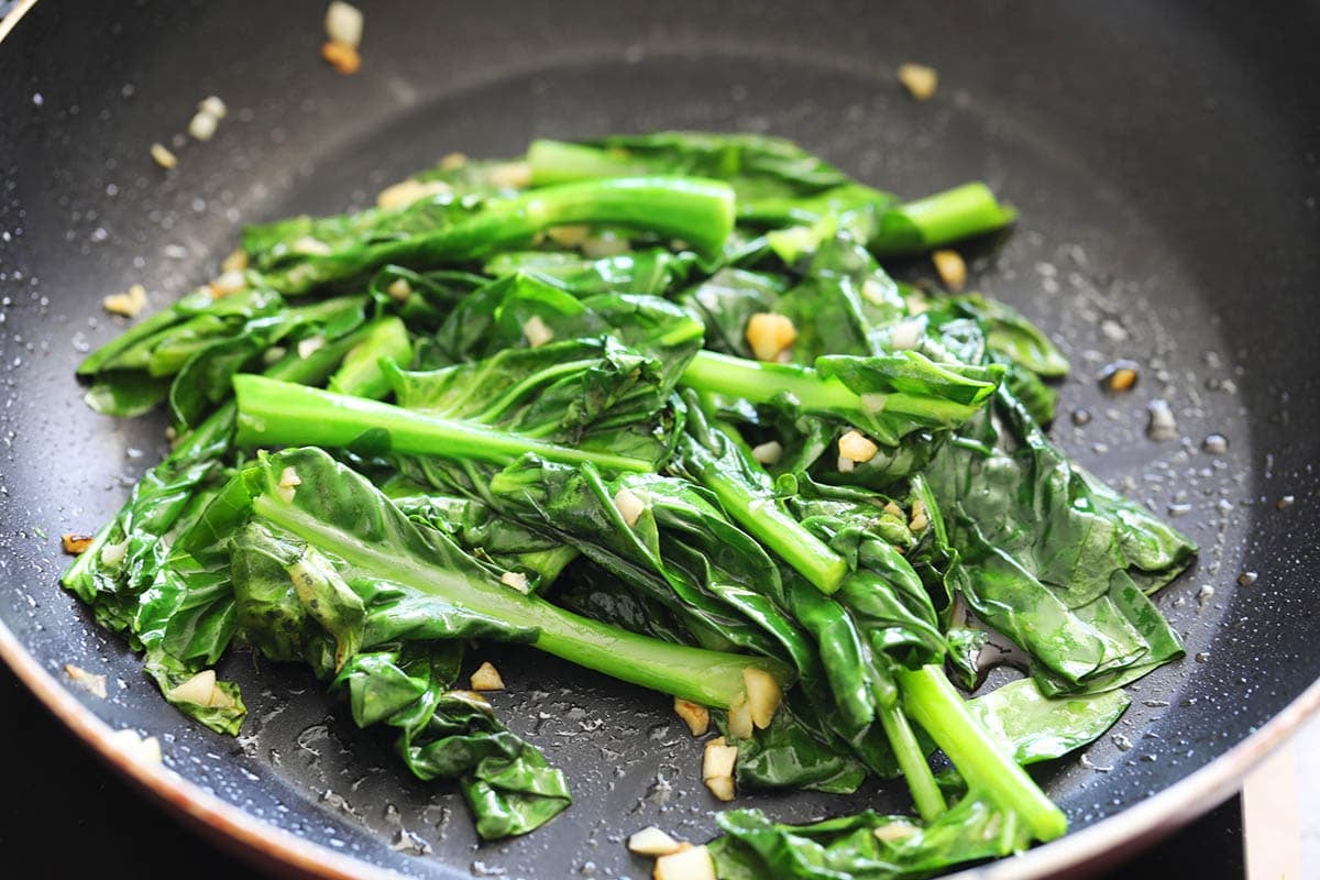 Gai lan with oyster sauce in a pan.