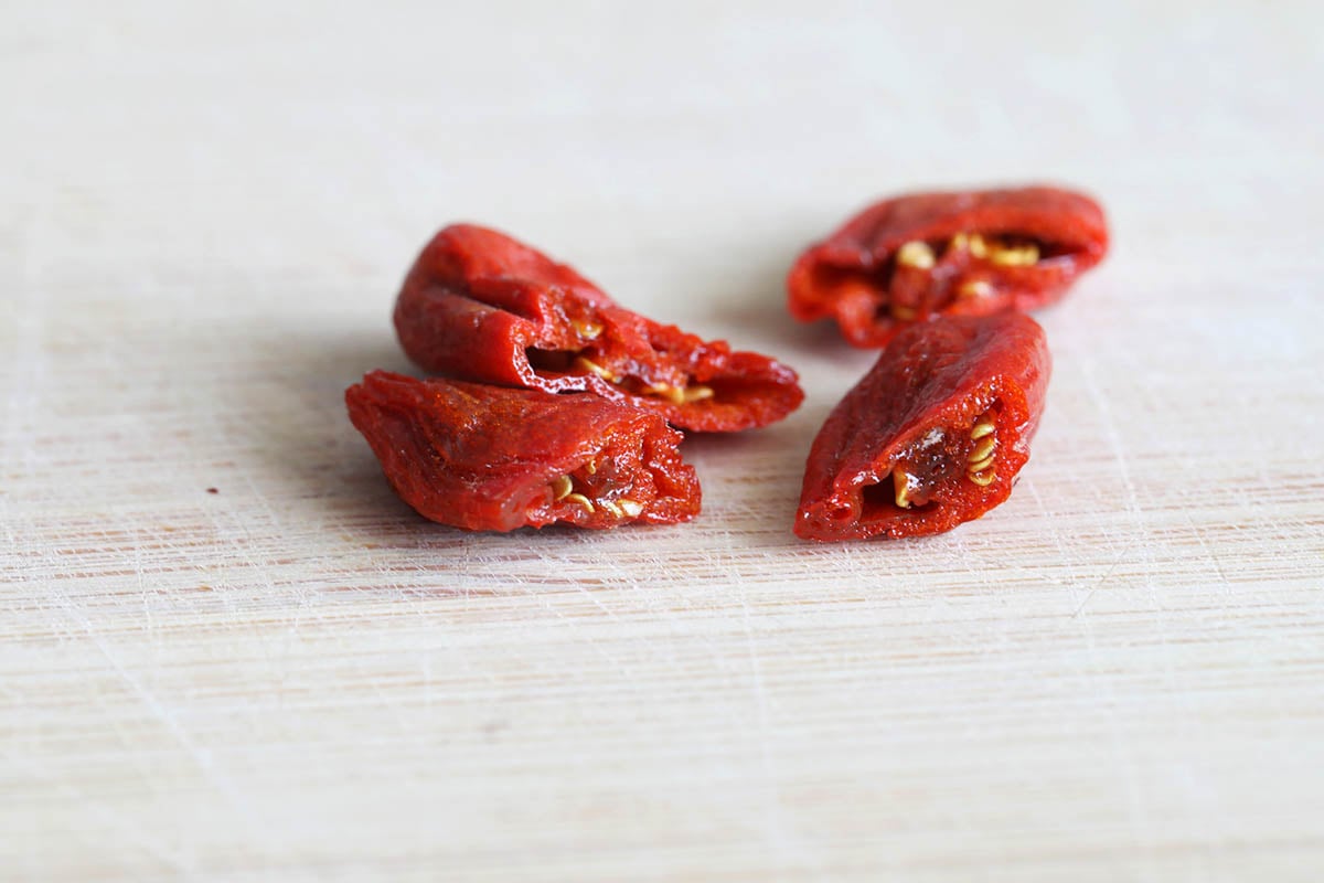 Sliced goji berries on a chopping board.