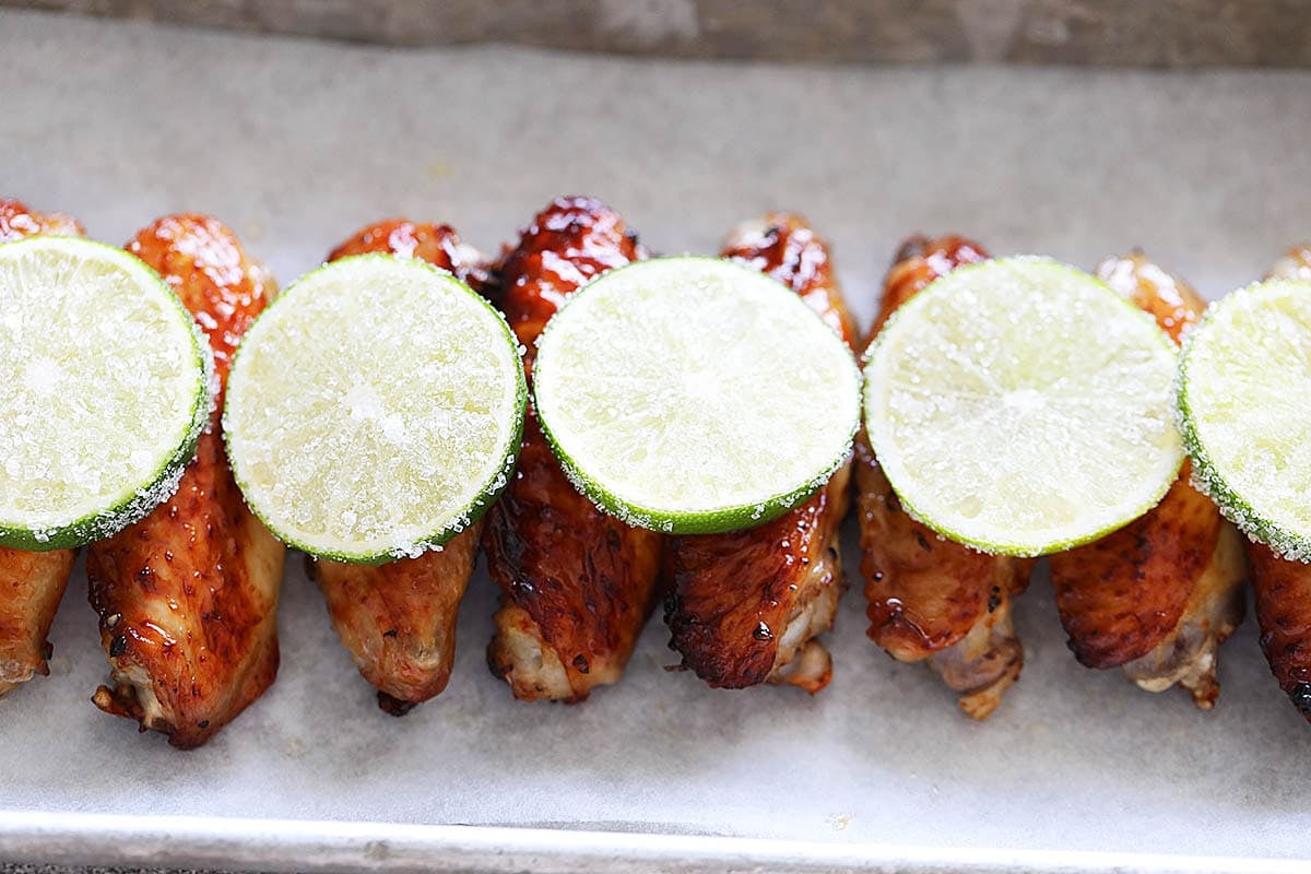 Golden chicken wings topped with sugared lime slices.