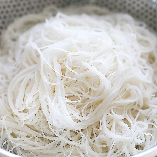 Rice noodles in a colander.