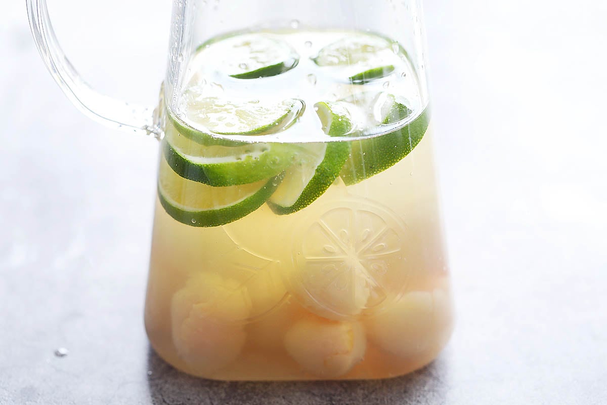 Lime slices and lychee in a pitcher.