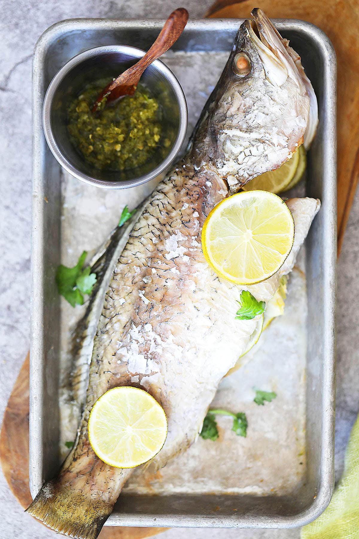 Salt baked fish recipe using seabass, garlic, and lime slices.