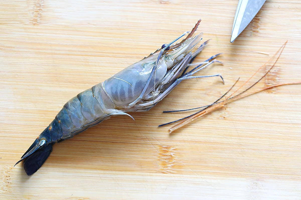 River prawn and its antennae on a chopping board.
