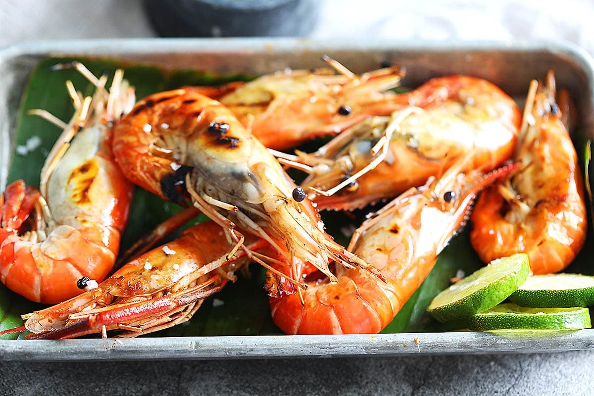 Thai grilled prawns served with homemade Thai seafood sauce and lime slices.