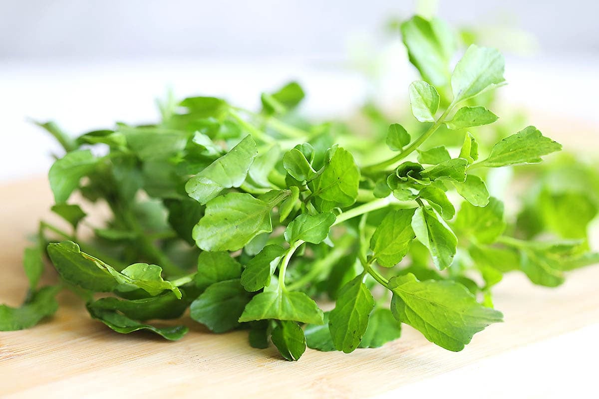 Watercress on a chopping board.