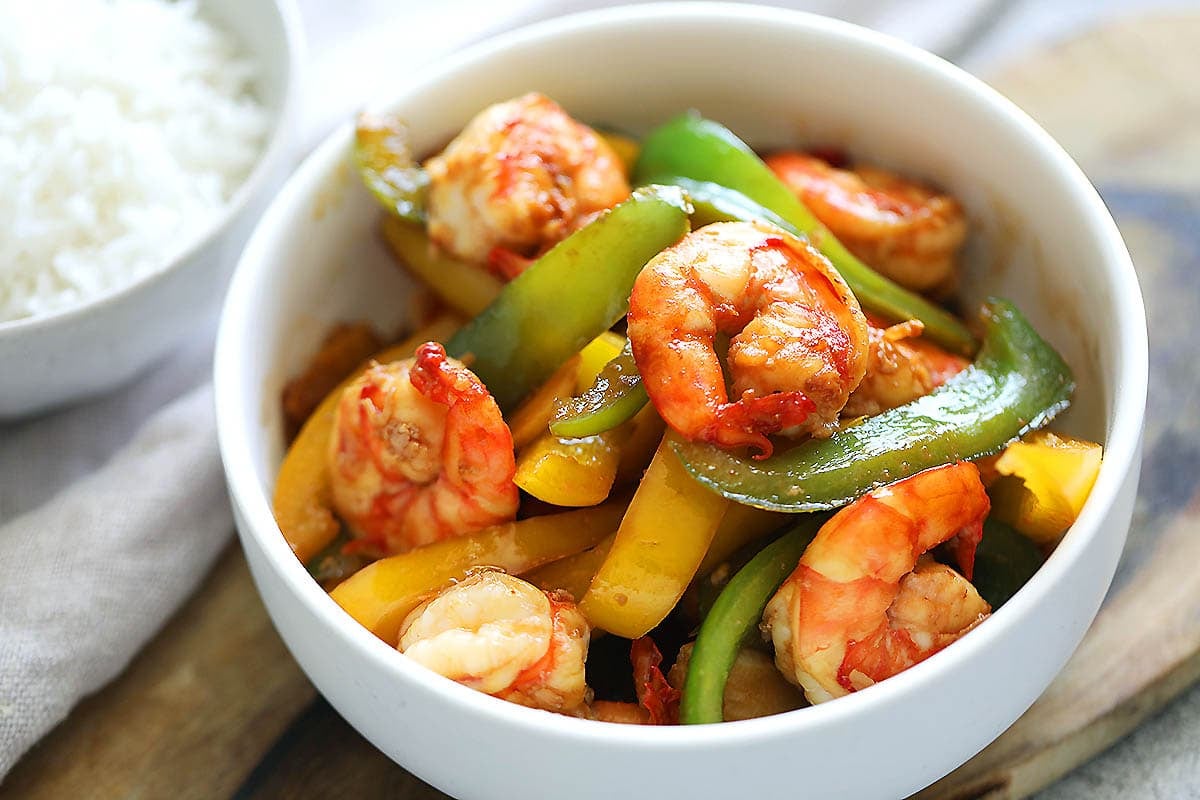 Bell pepper and shrimp stir fry served with a bowl of white steamed rice.