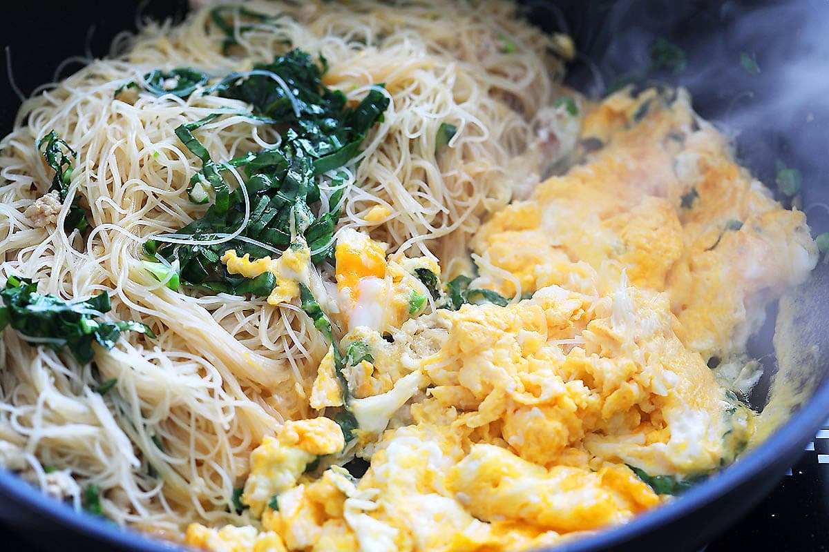 Stir fried rice vermicelli and scrambled eggs in a pan.