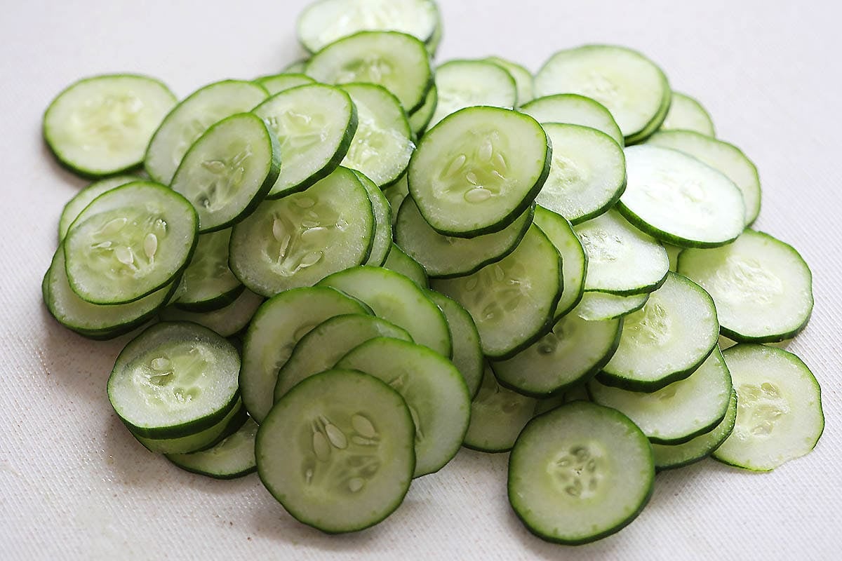 Cucumber slices on a chopping board.