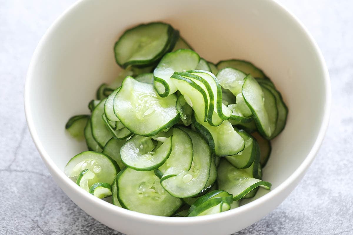 Slightly pickled cucumber slices in a bowl.