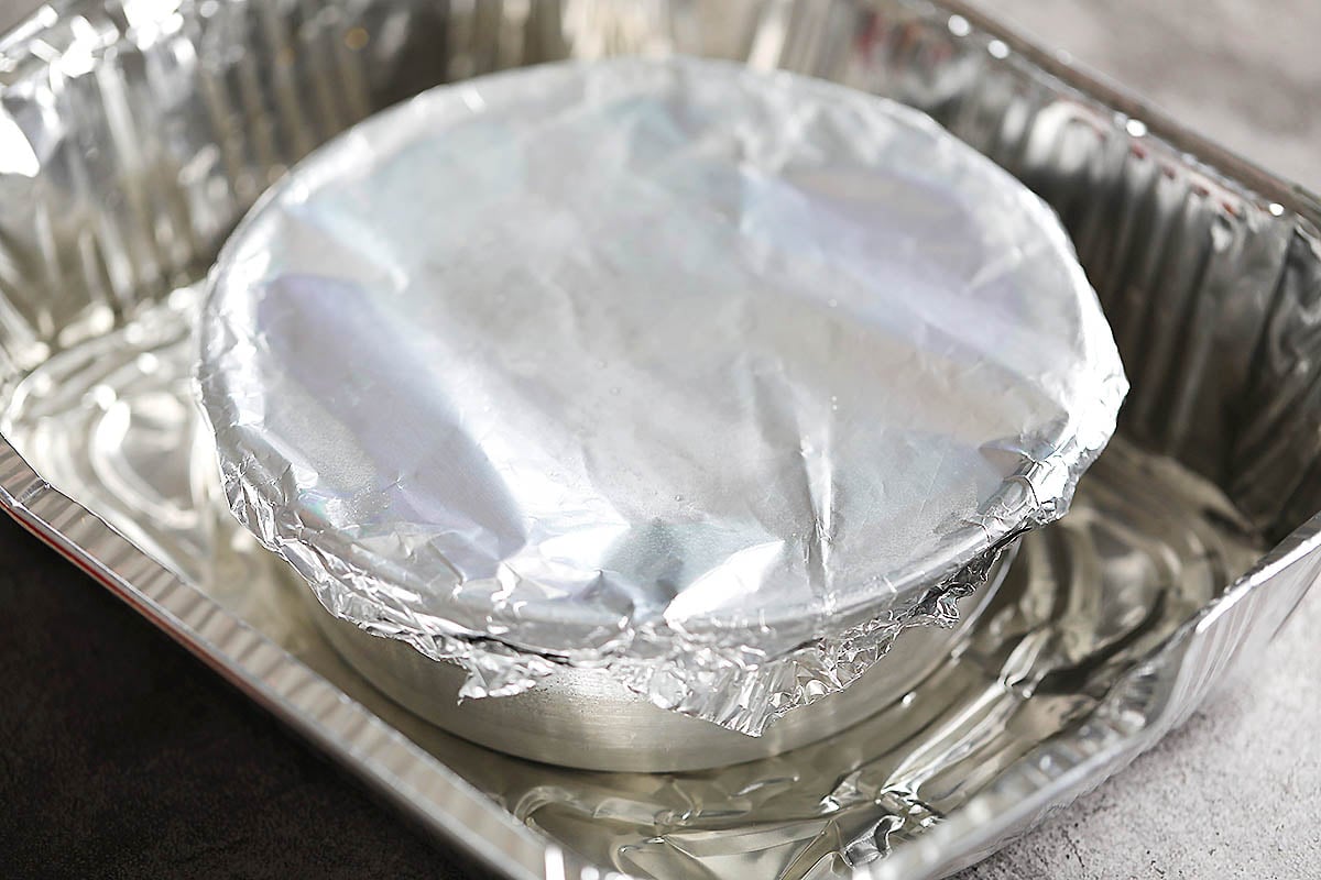 Covered cake pan in a warm water bath.