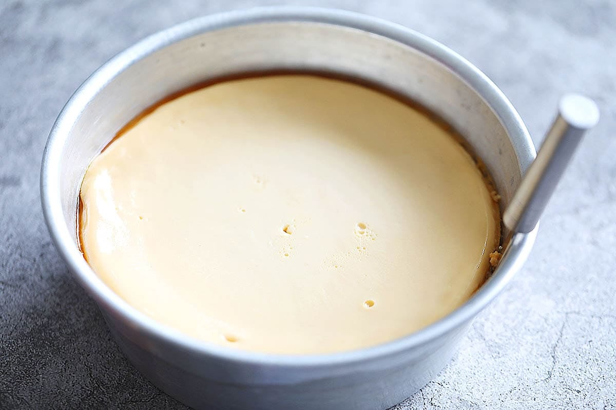 Venezuelan flan in a cake pan with a knife.
