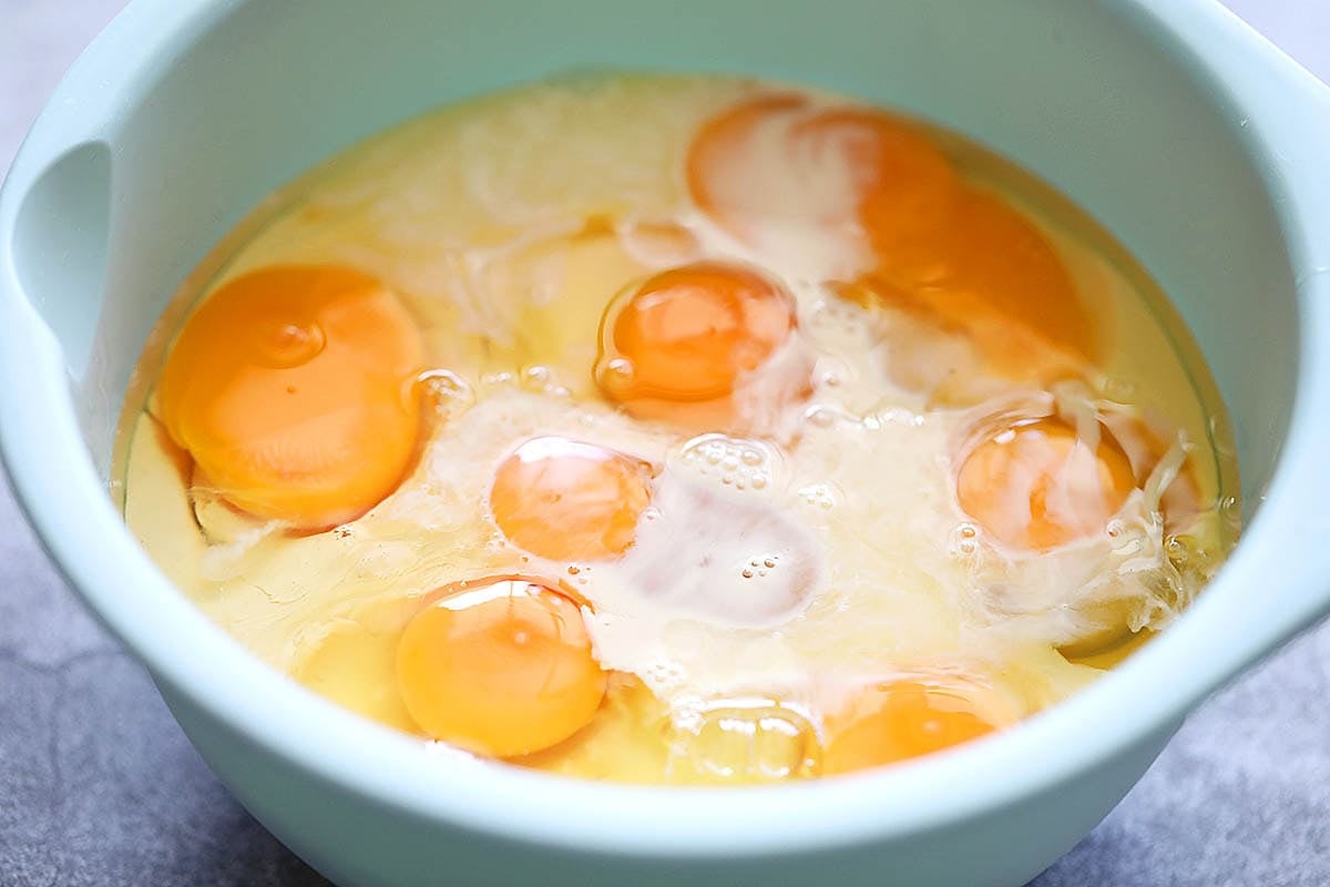 Eggs, condensed milk, and evaporated milk in a large bowl.