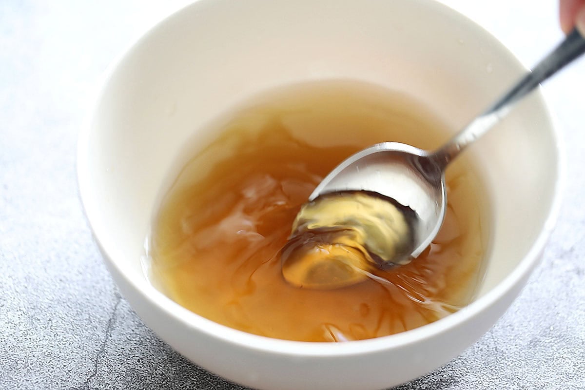 Ingredients for nuoc cham being stirred with a spoon.