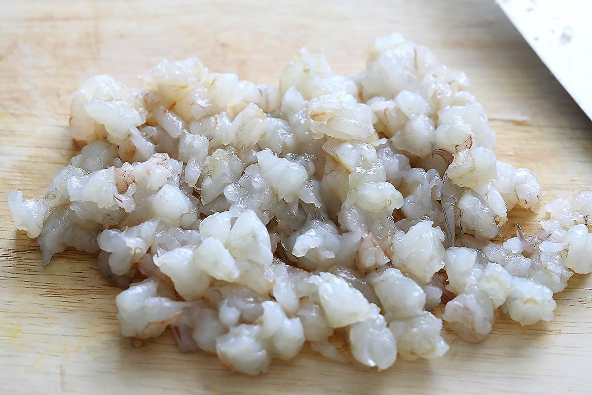 Small shrimp pieces on a chopping board.