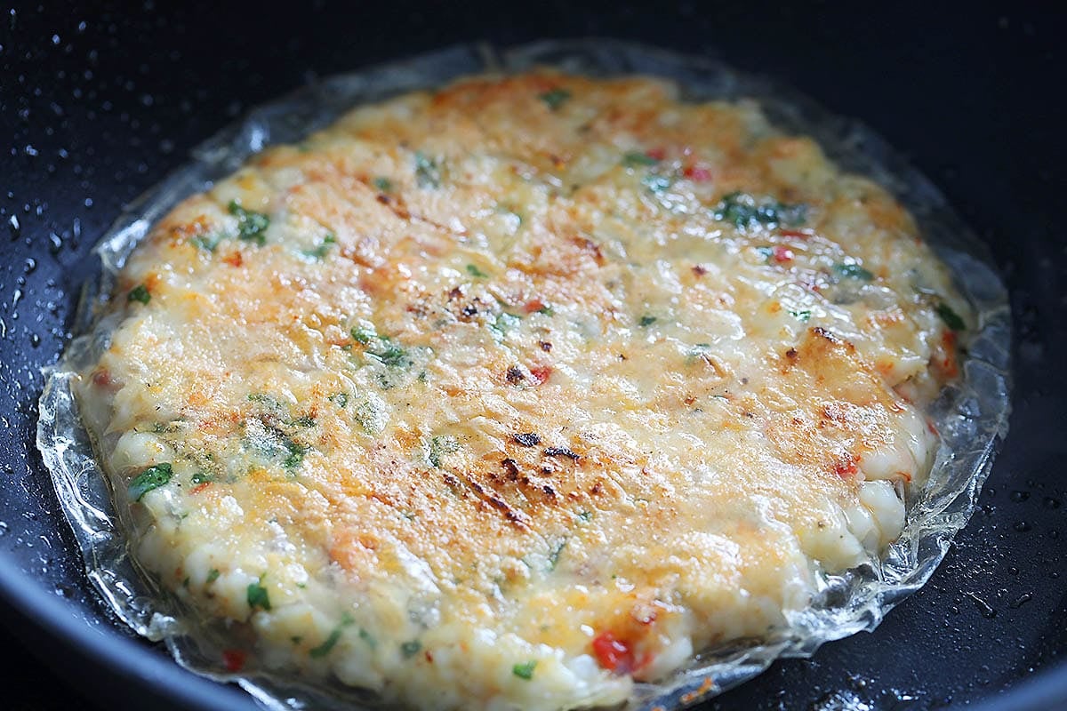 Light golden brown Vietnamese shrimp cake in a pan.