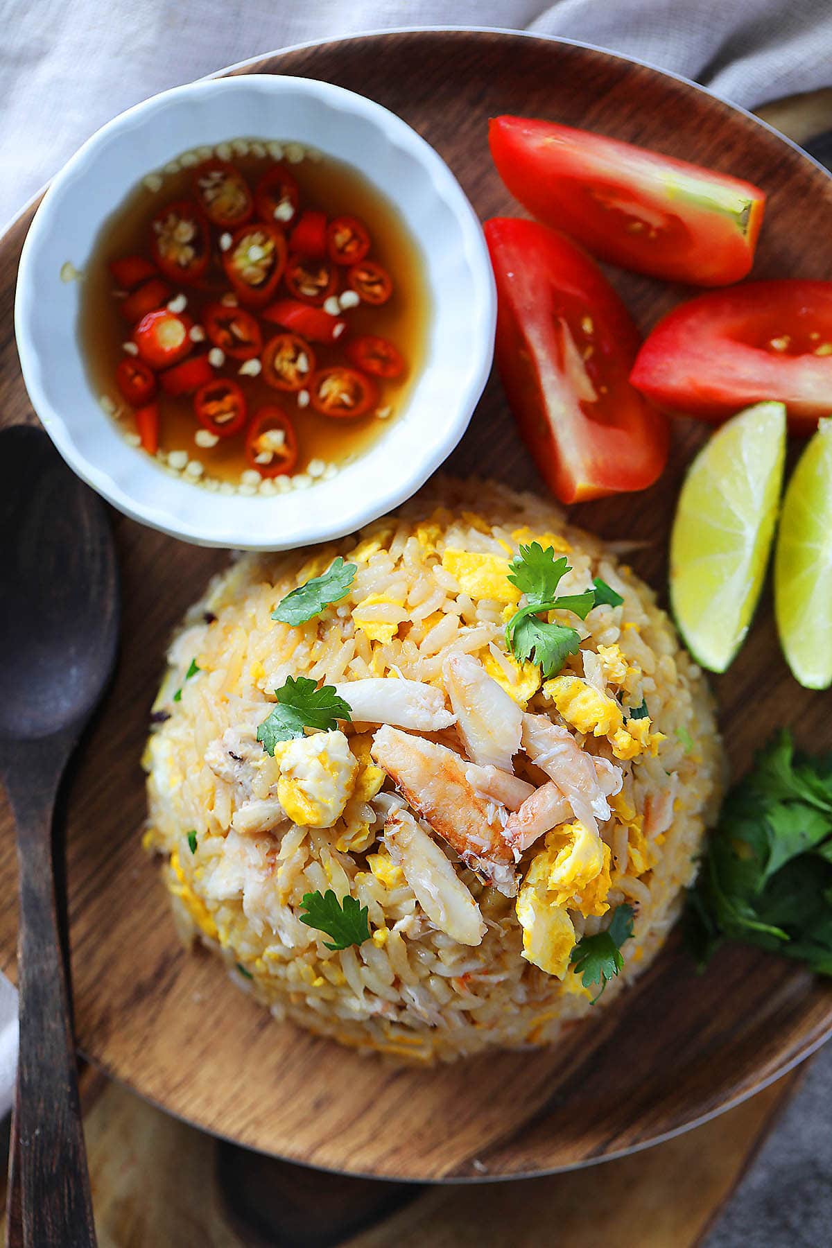 Crab fried rice served with lime wedges, tomato wedges, and nam pla prik.