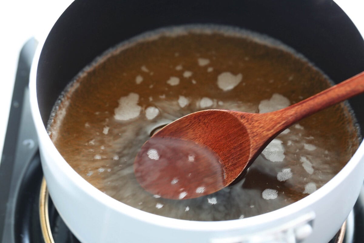 Homemade dashi broth, mirin, sake, and soy sauce in a saucepan.