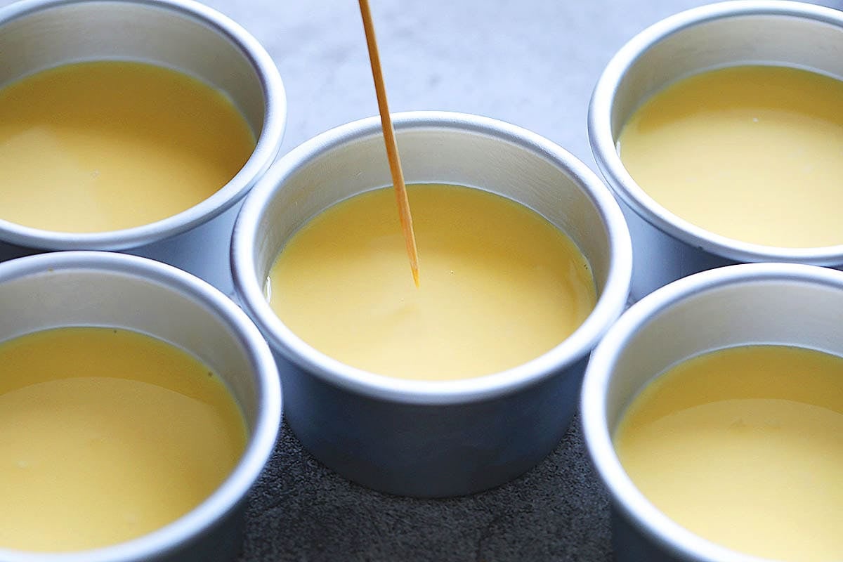 Toothpick poking air bubbles on the surface of the egg mixture.