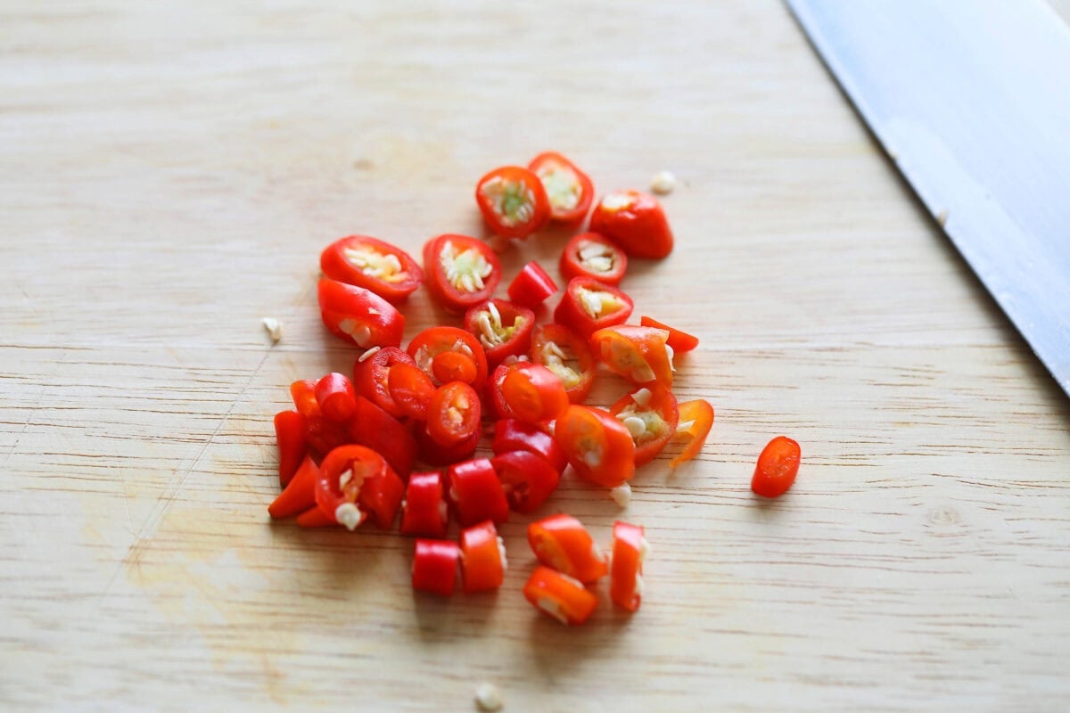 Chopped bird's eyes chilies on a chopping board.