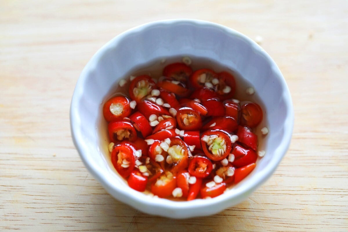 Fish sauce and chopped chilies in a saucer.