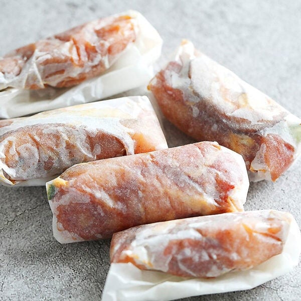 Uncooked paper wrapped chicken.