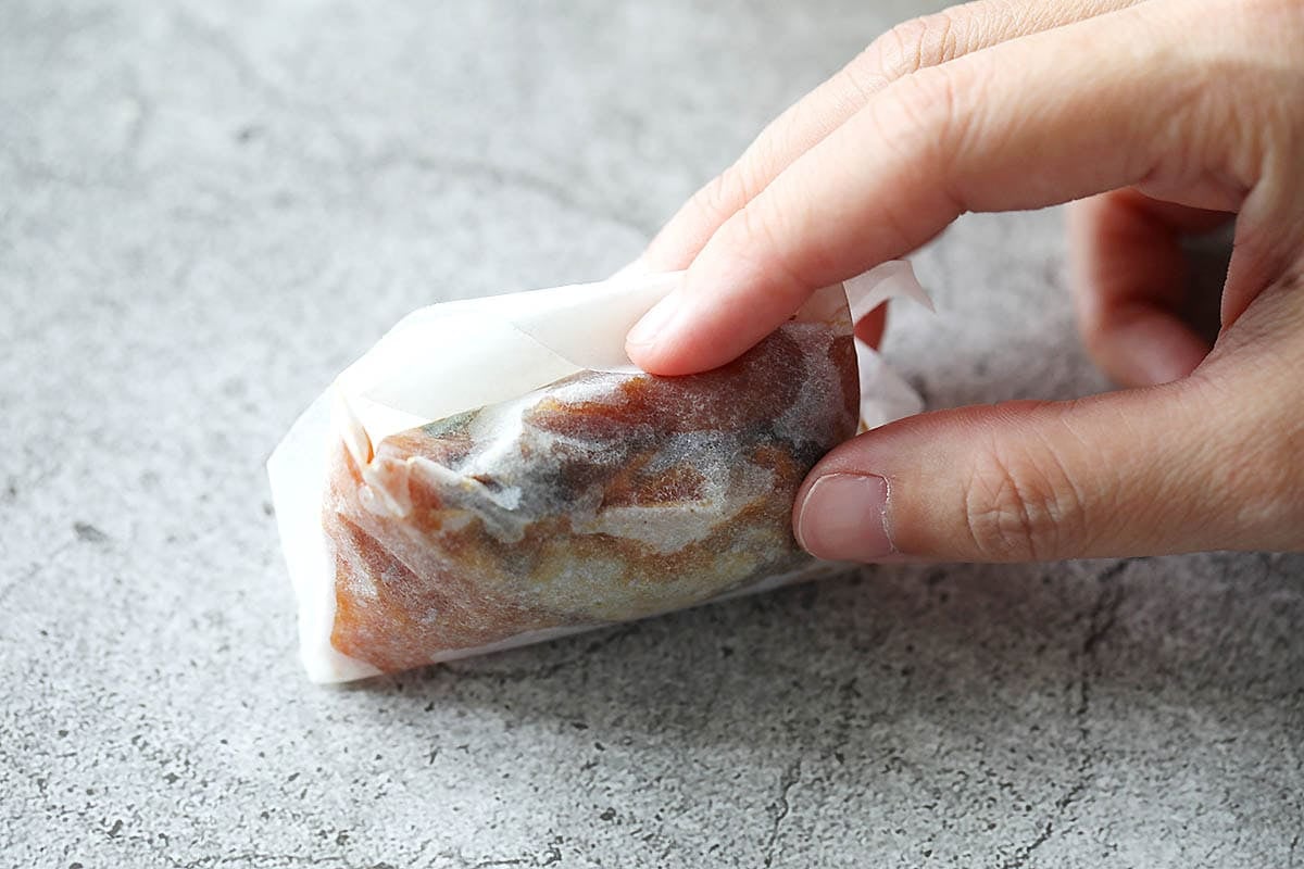 Top corner of the parchment paper being tucked into the pocket.
