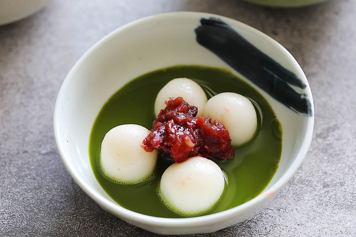 Assemble matcha zenzai with a bowl of red ben soup on the bottom, top with shiratama dango and pour the match tea over.