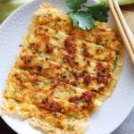 Prawn cake served with a side of chili sauce.