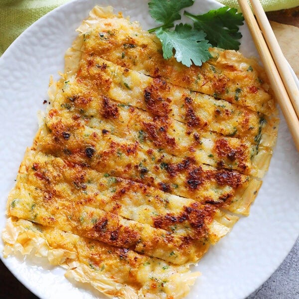 Prawn cake served with a side of chili sauce.