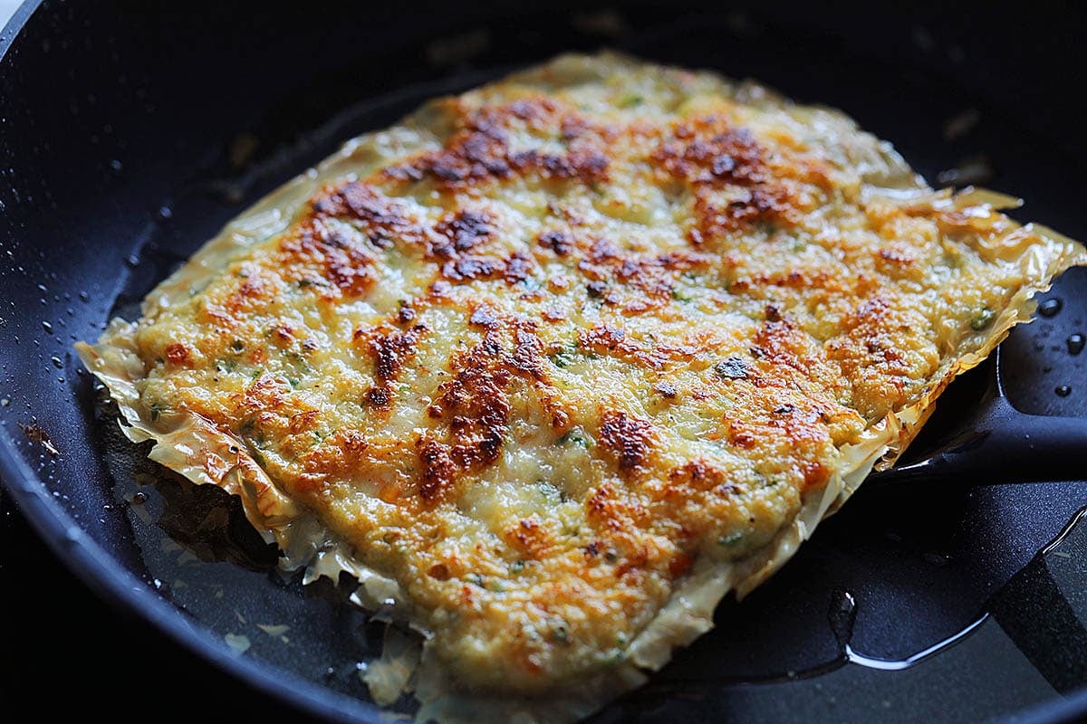 Golden and crispy prawn cake in a pan.