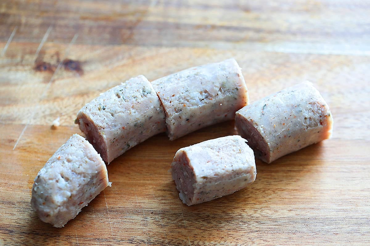 Pieces of pork sausages on a chopping board.