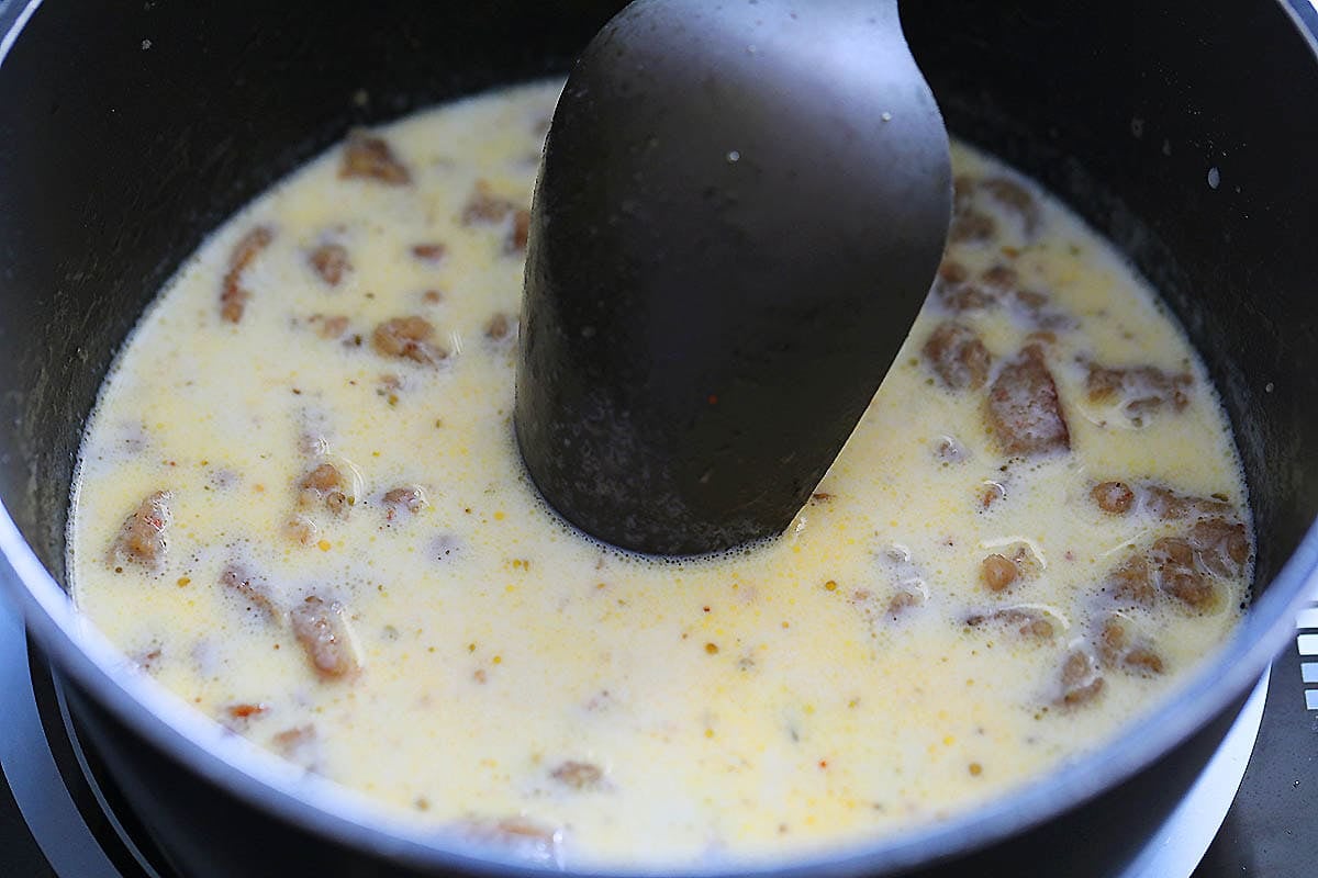 Milk and sausage in a saucepan.
